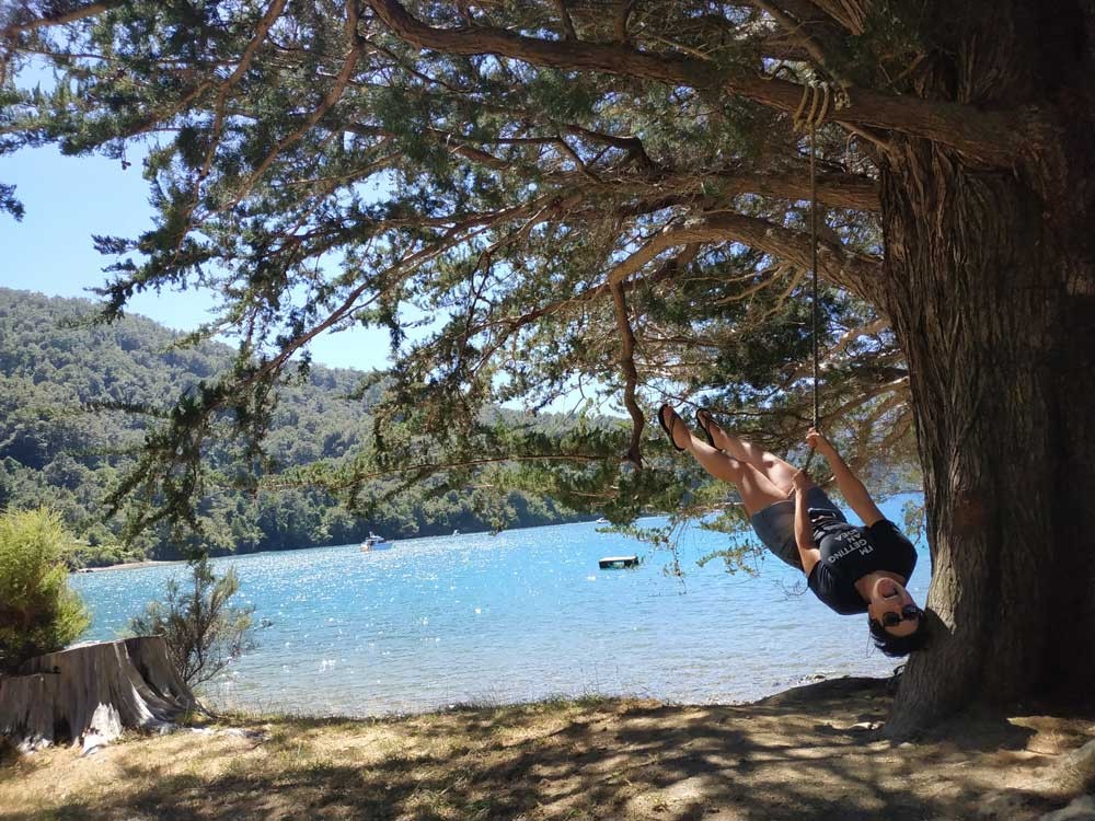 chica en un columpio y de fondo un lago